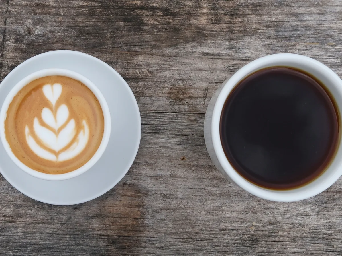 Latte and black coffee on a wooden table